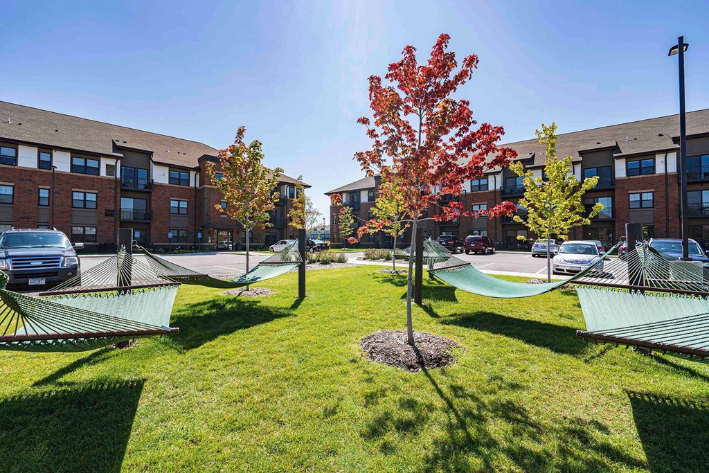 hammocks in the grass in front of an apartment building