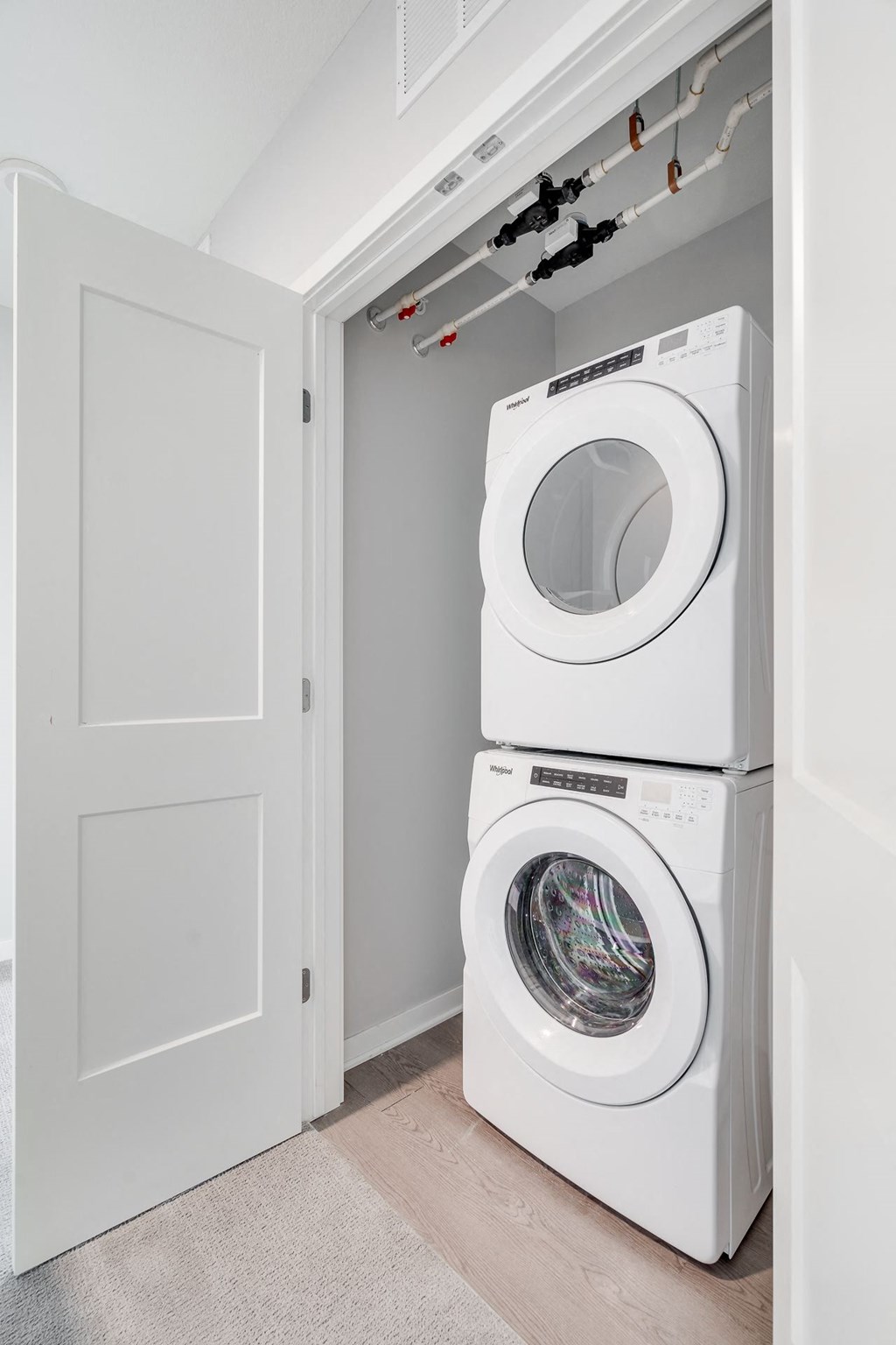 Stacked washer and dryer in laundry closet in luxury apartment home at Aspire at CityPlace in Woodbury, Minnesota
