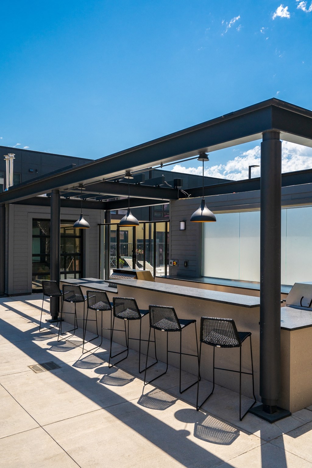 Outdoor cooking area with ample counter space and six bar stools at the bar at Aspire at Cityplace
