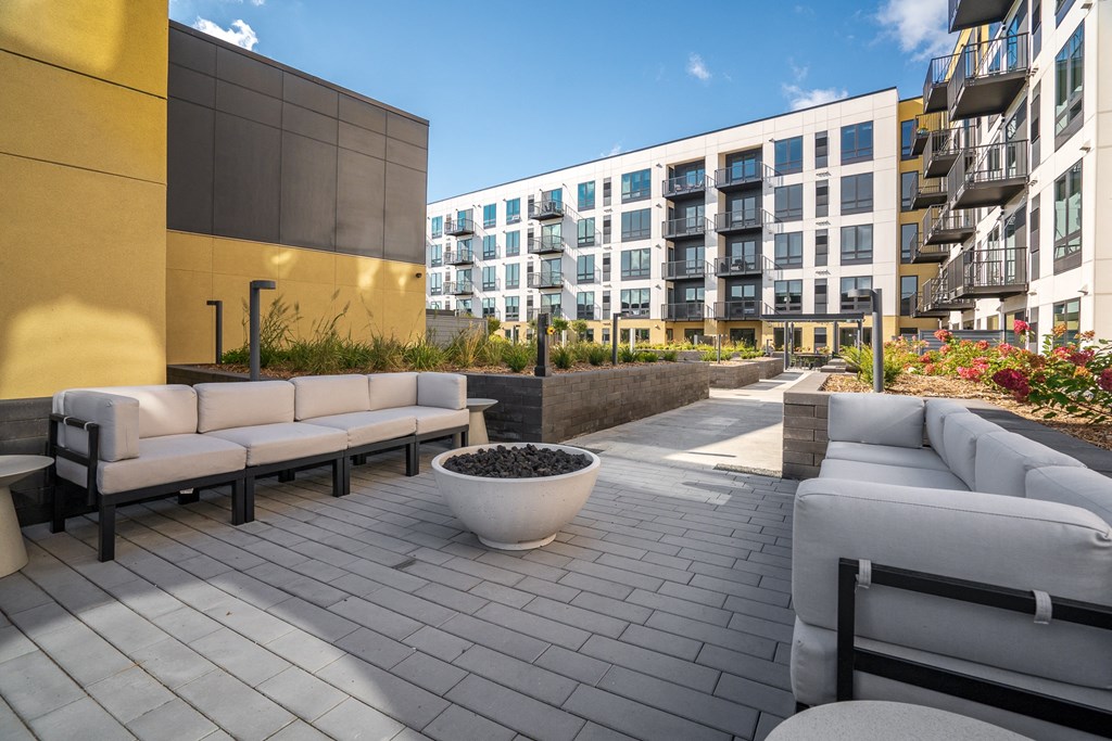 Outdoor seating area with couches and firepit in the courtyard at Aspire at CityPlace Woodbury