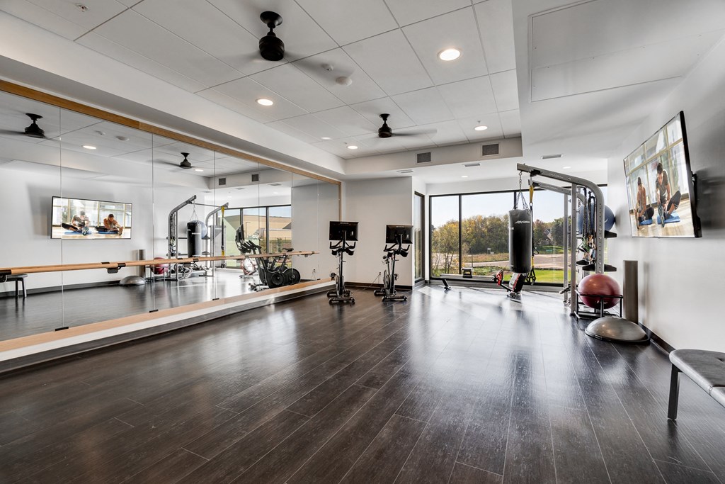 Yoga and cycling studio with full-wall mirrors and windows and open space for exercising
