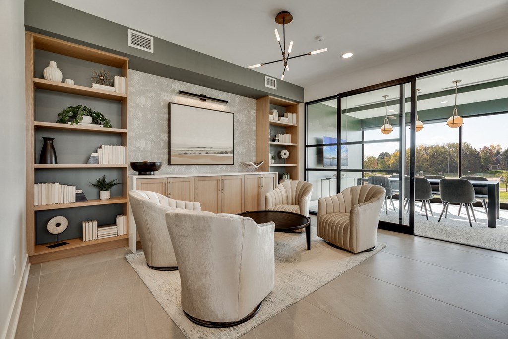 Community sitting area with chairs and built in shelving and connected conference room