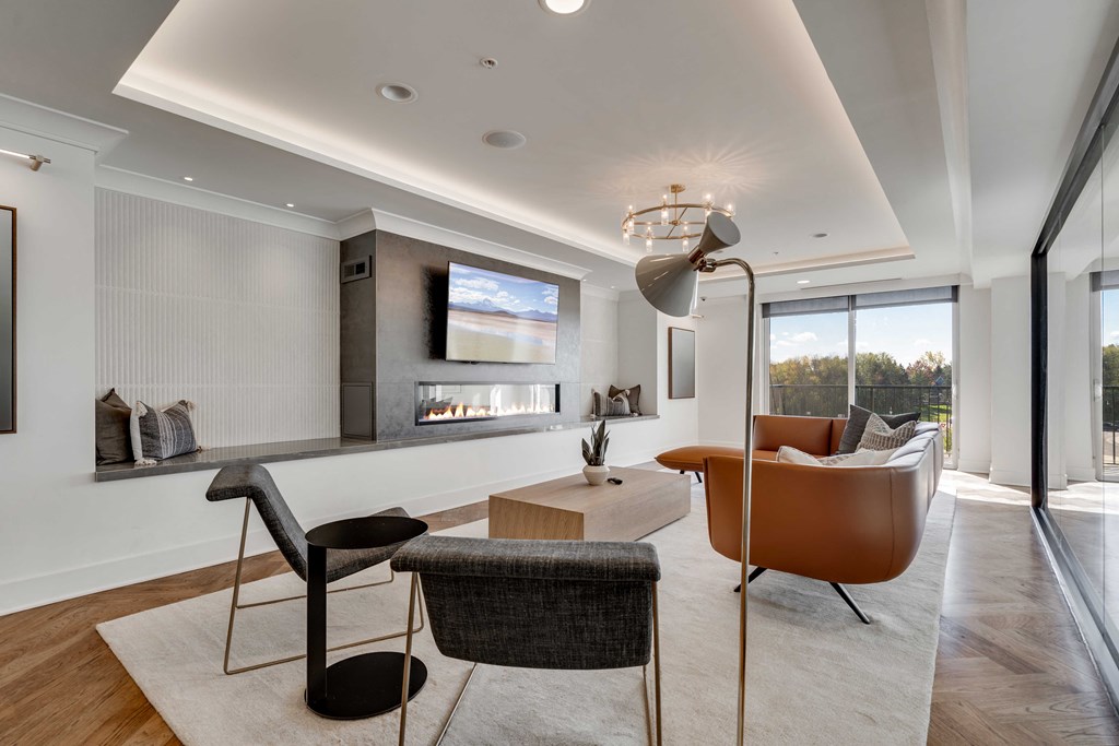 Community lounge space with electric fireplace and balcony at Aspire at CityPlace