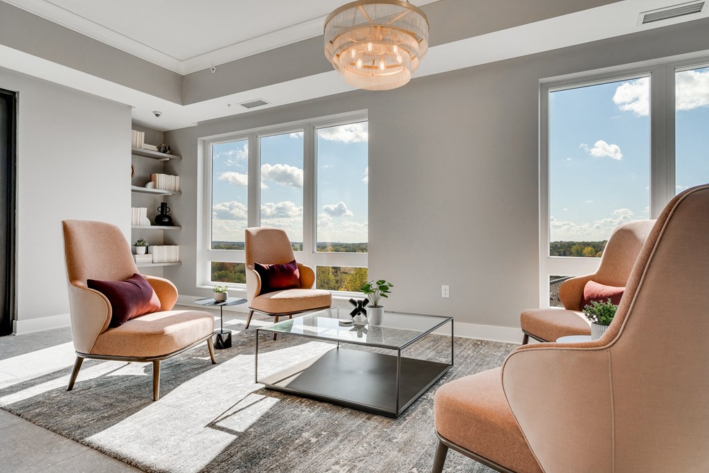 Seating area with large windows and four chairs facing each other in a community space