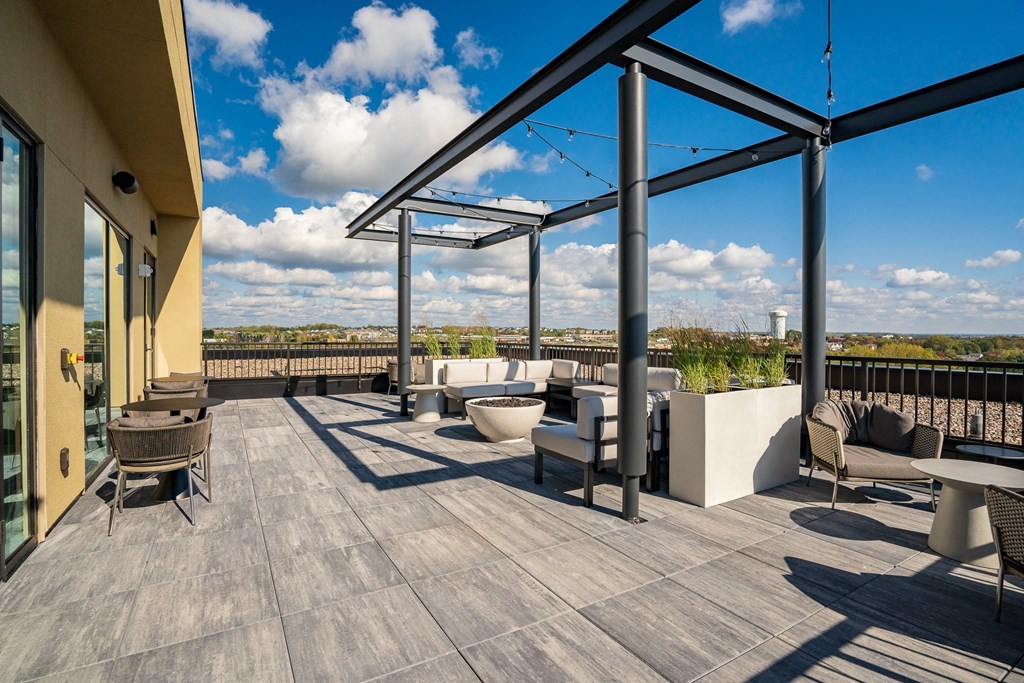 Rooftop lounge with seating, fire pit and string globe lighting over looking Woodbury MN