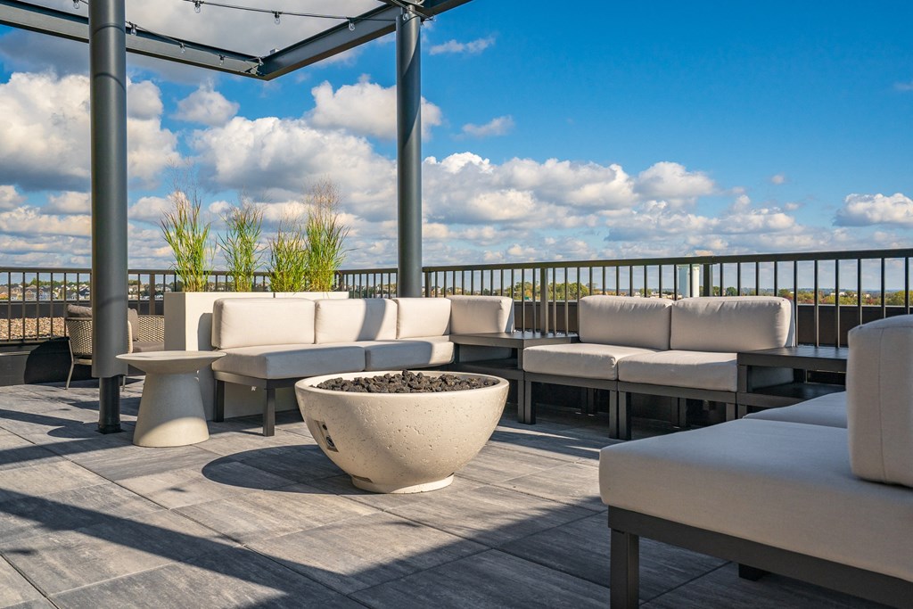 Rooftop lounge with seating, fire pit and string globe lighting over looking Woodbury MN