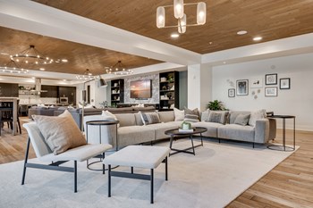Aspire-at-CityPlace-Woodbury-MN-luxury-apartments-community-room Community room with professional kitchen and large sectionals around a TV at Aspire - Photo Gallery 5