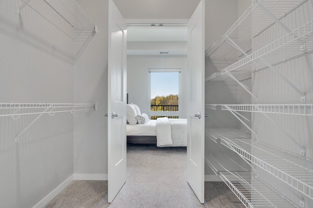 Large walk in closet with double doors and wire shelves on each side in 2 bedroom apartment in Woodbury MN 55125