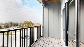 a balcony with a black metal railing and a window to the bedroom