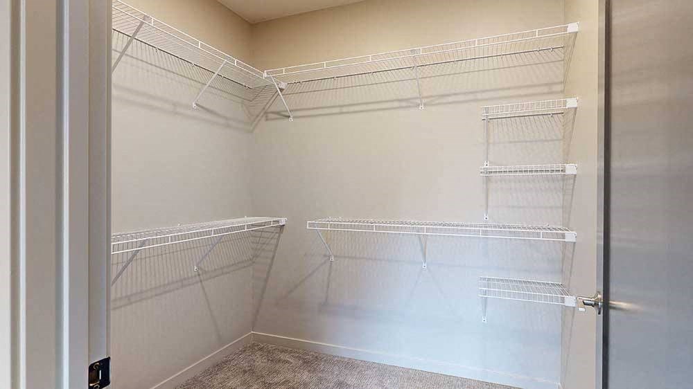 a walk-in closet with built-in wire shelves and hanging space