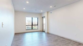 a spacious living room with a large window to bring in plenty of natural light