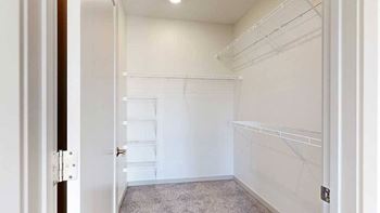 a walk in closet with built-in shelving and hanging space
