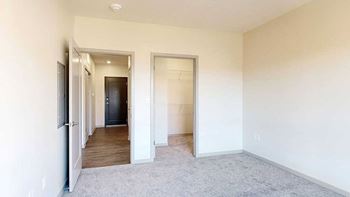 A spacious room with a carpeted floor and white walls.