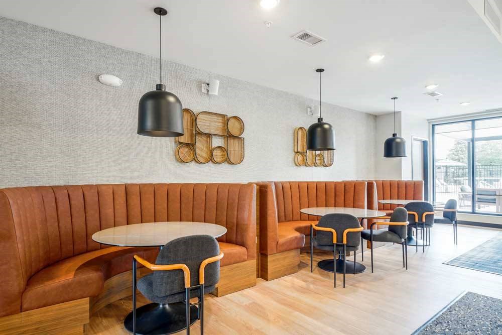 A clubroom with a modern seating area with half-circle leather booths, perfect for working or study spaces.