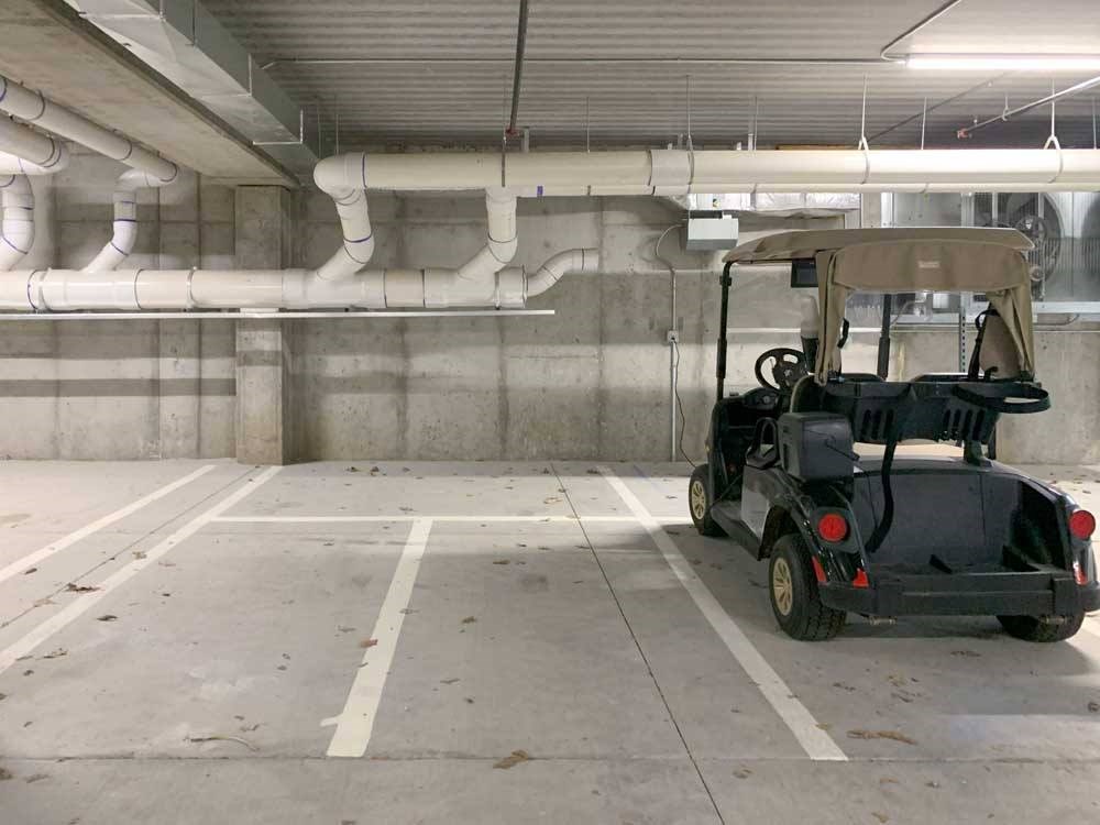 a golf cart parked in a dedicated space in the underground climate-controlled garage