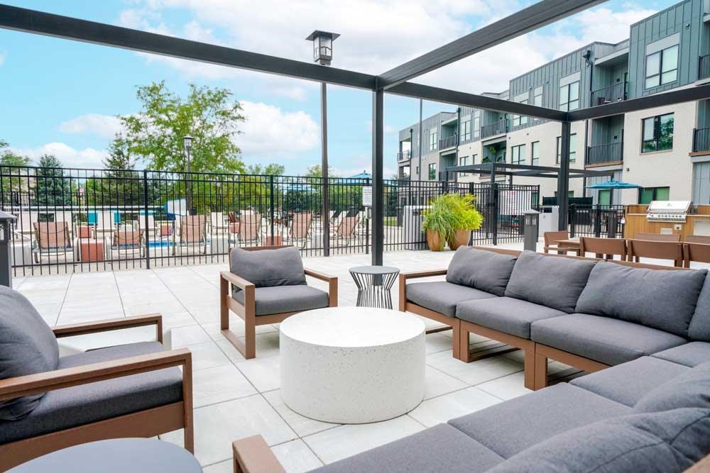A courtyard patio with lounge seating and a pergola frame.