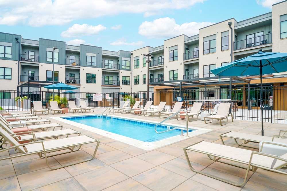 A lounge pool surrounded by several lounge chairs and umbrellas for shade.