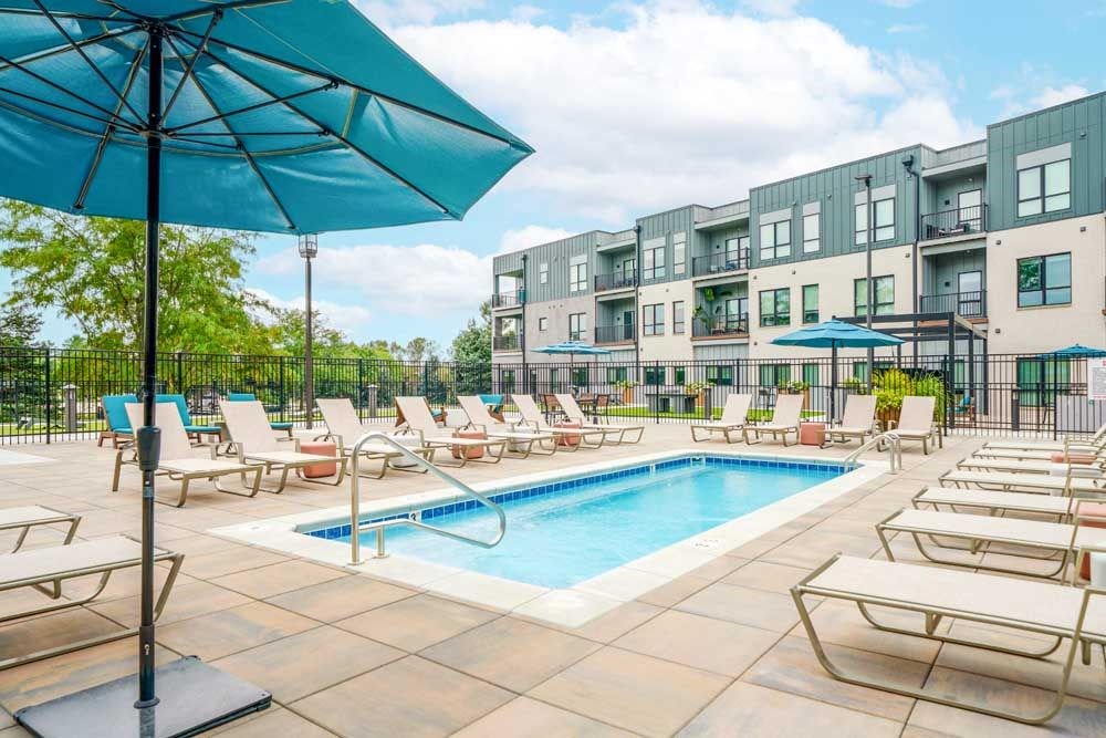 A lounge pool surrounded by several lounge chairs and umbrellas for shade.