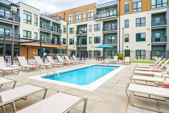 A lounge pool surrounded by several lounge chairs and umbrellas for shade.