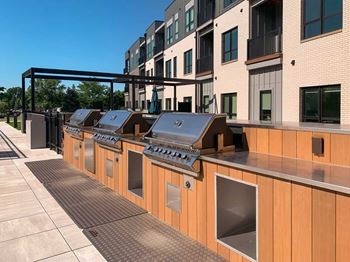 a row of stainless steel gas grilling stations with built in counterspace