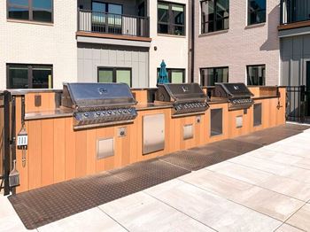 a row of stainless steel gas grilling stations with built in counterspace
