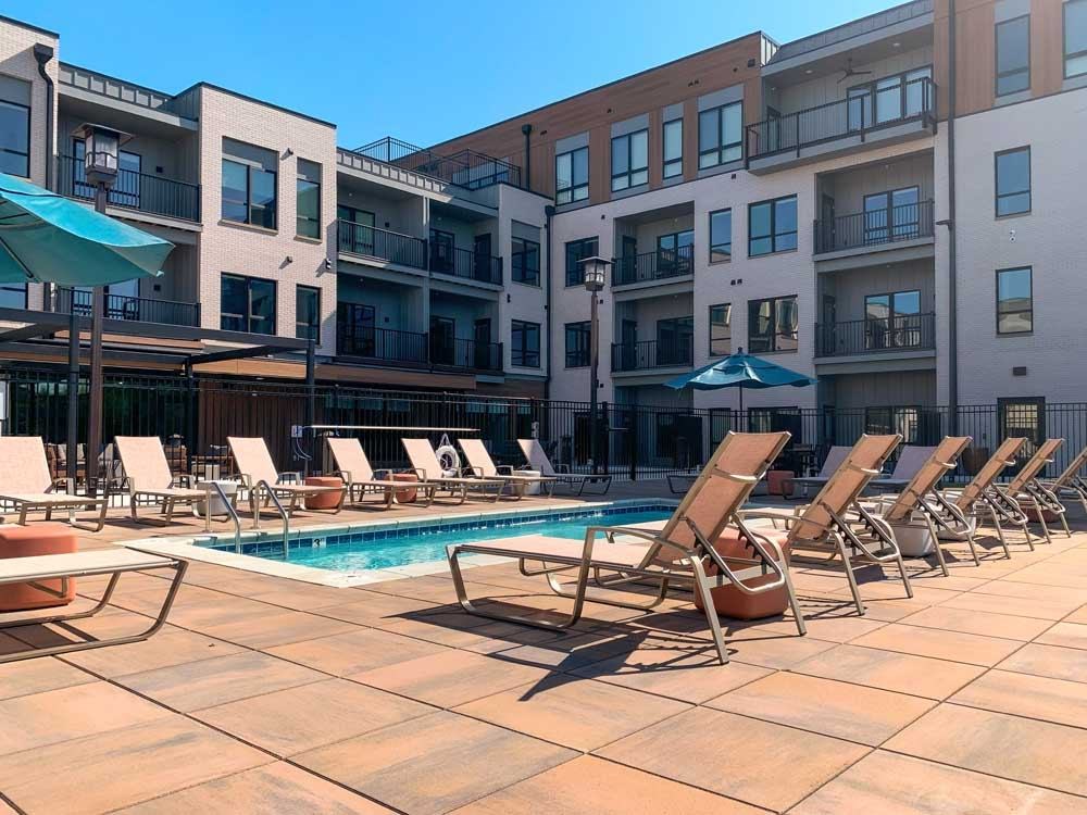 Courtyard - Lounge Pool a lounge pool with several chaise lounge chairs and umbrellas surrounding it