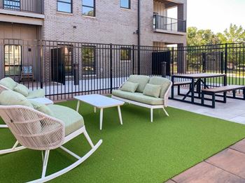 a casual seating area with plush rocking chairs and bench seating next to a picnic table