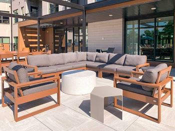 a social seating area with a sectional and chairs surrounding a table