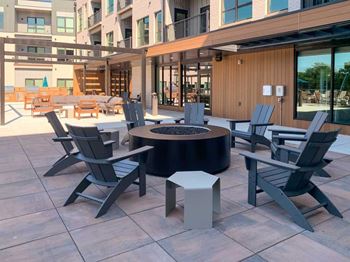 a firepit with several Adirondack chairs surrounding it