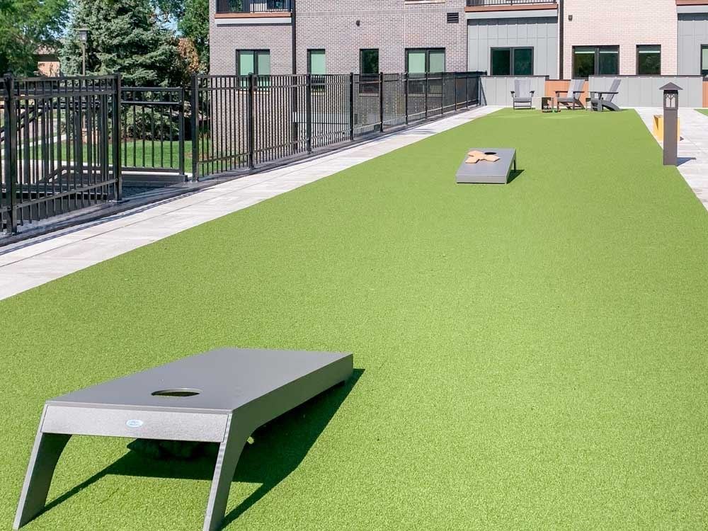 a turf green space with a set of cornhole boards
