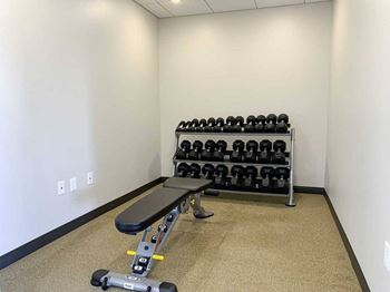 a fitness center with a bench and free weights