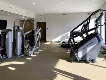 a fitness center with a variety of equipment including a Stair Master