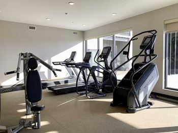 a fitness center with treadmills, elliptical machines, and stair master