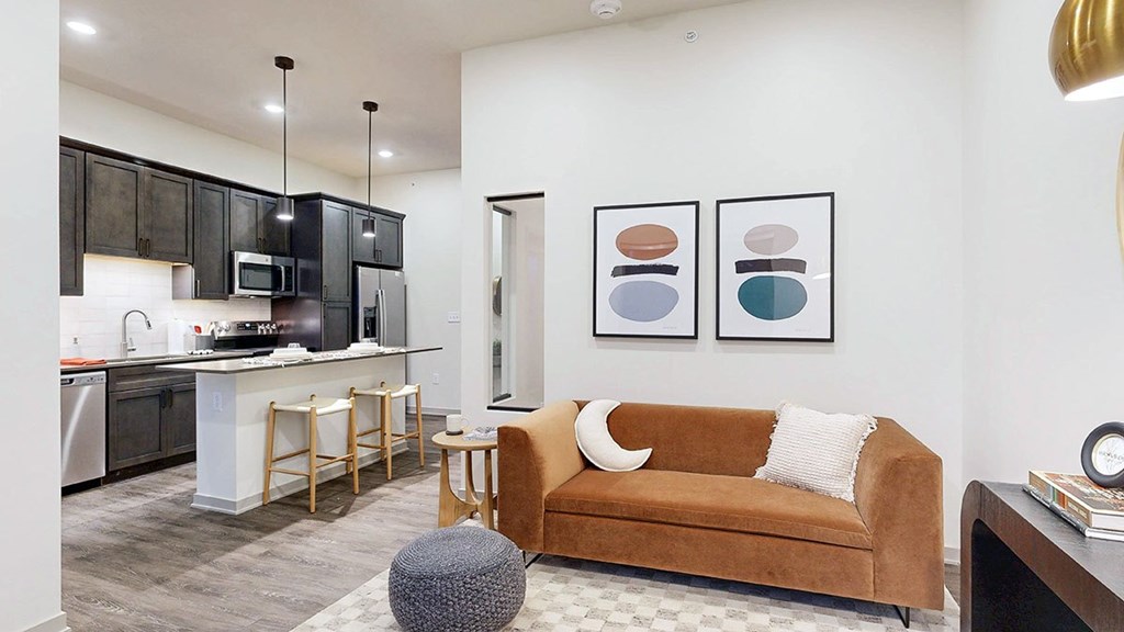 a studio apartment living room with a sofa and natural light from the window