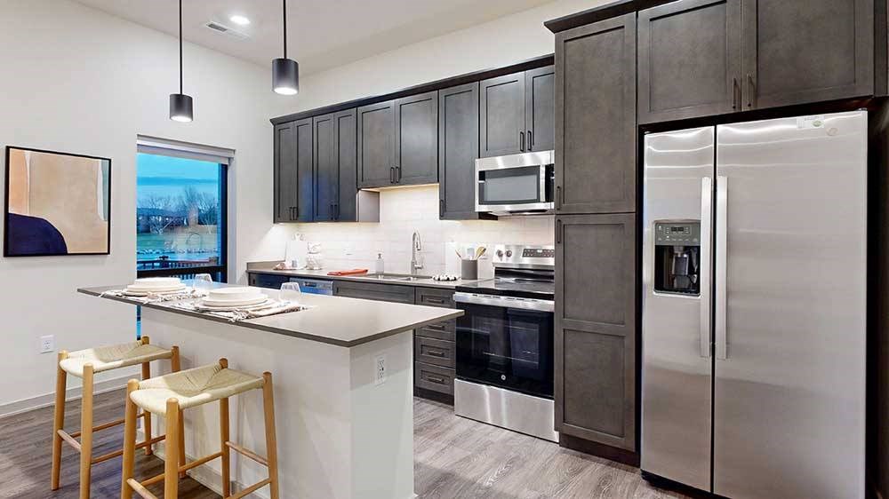 a kitchen with a full-size refrigerator, range, and microwave