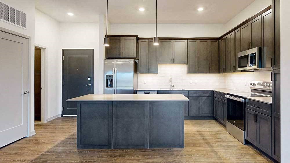 a modern kitchen with dark wood cabinets and stainless steel appliances
