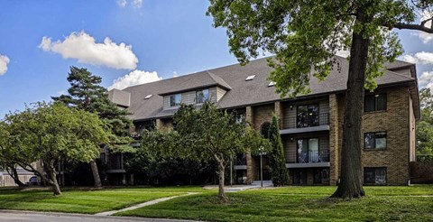 An apartment building with mature trees in front of it