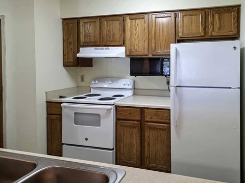 A kitchen with a white stove and refrigerator.