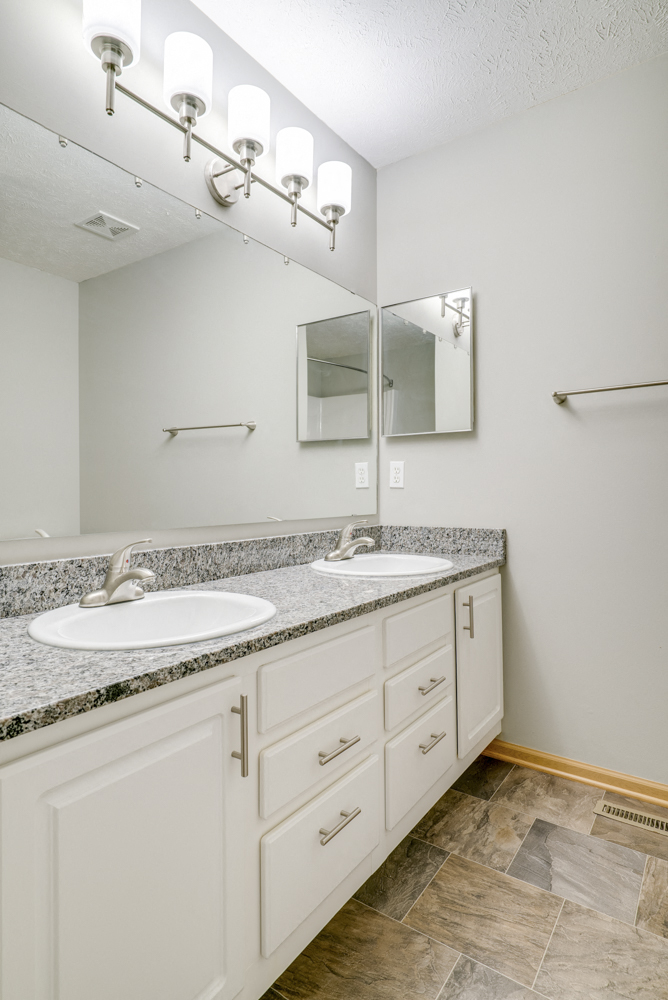 bathroom with dual sinks and white cabinetry at Cascade Pines Duplex and townhomes