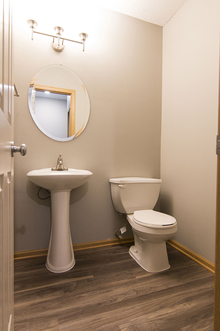 Half-bath with hardwood-like flooring at Cascade Pines Town-homes Lincoln Nebraska