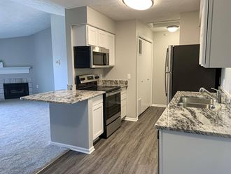 Renovated kitchen with white cabinets and stainless steel appliances at Eagle Run Apartments in Omaha Nebraska