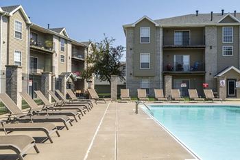 Outdoor swimming pool with lounge chairs at Eagle Run Apartments in northwest Omaha 68164