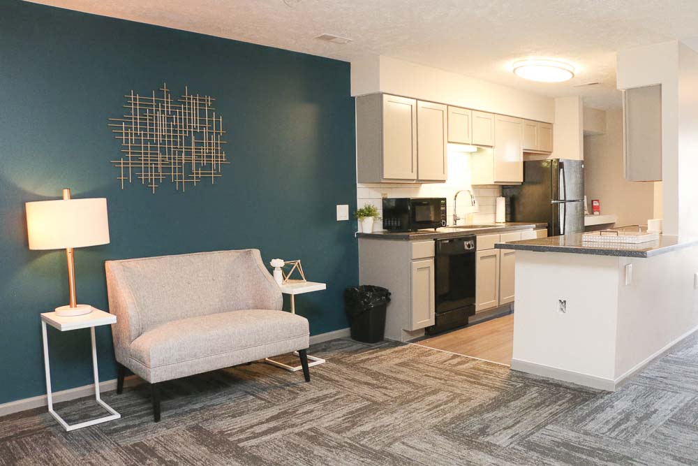 View of sitting chair and kitchen in the clubhouse-Eagle Run Apartments in Omaha NE