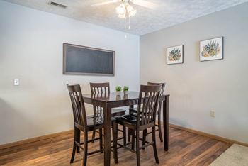 A dining room with a wooden table and chairs.