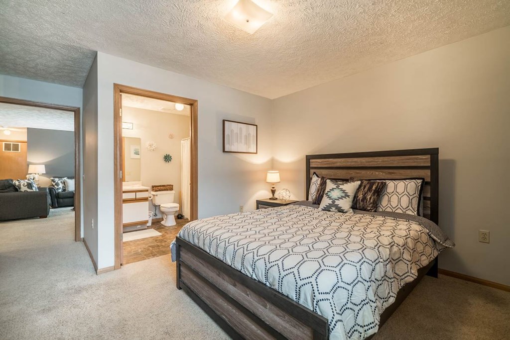 A bedroom with a large bed and attached bathroom