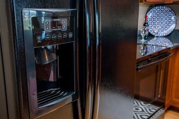 A black refrigerator with a water and ice dispenser on the left side.