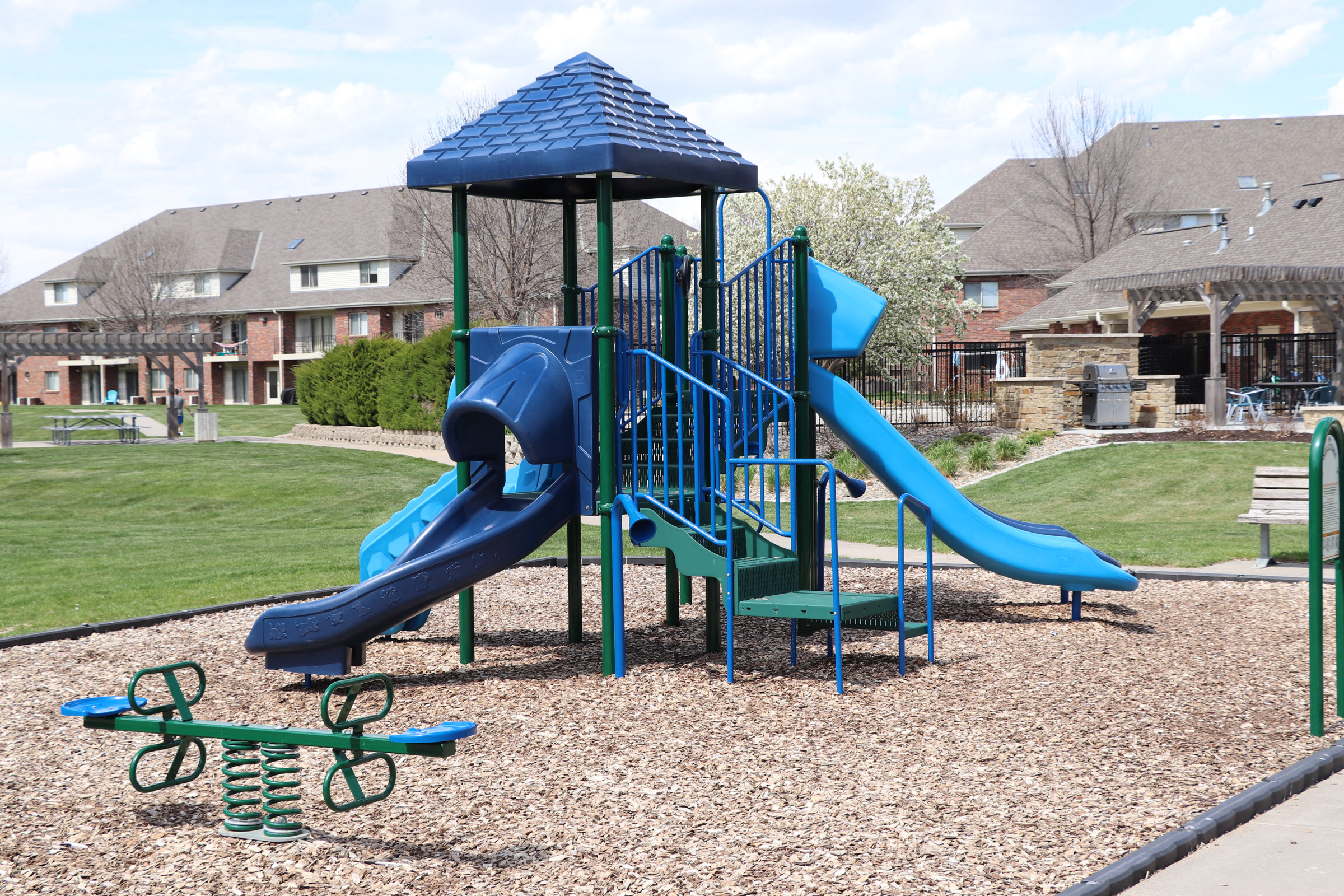 Children's playground with slides and a seesaw at Fountain Glen Apartments in Lincoln, NE