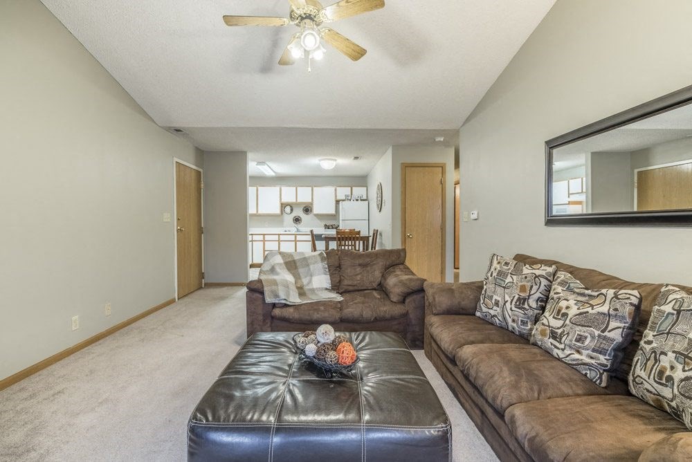 Furnished living room with brown sofa and black ottoman