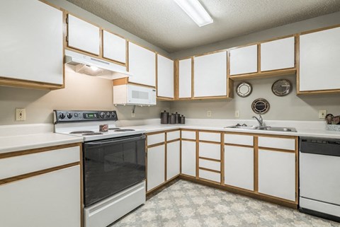 a kitchen with white cabinets and black appliances