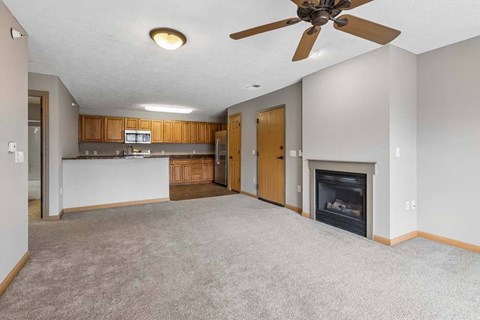 A living room with a fireplace and a ceiling fan.